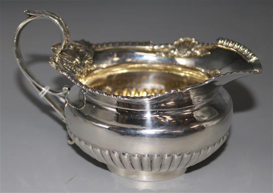 A Georgian silver cream jug by William Elliott (date mark rubbed), with gadrooned and shell cast rim, 7 oz.